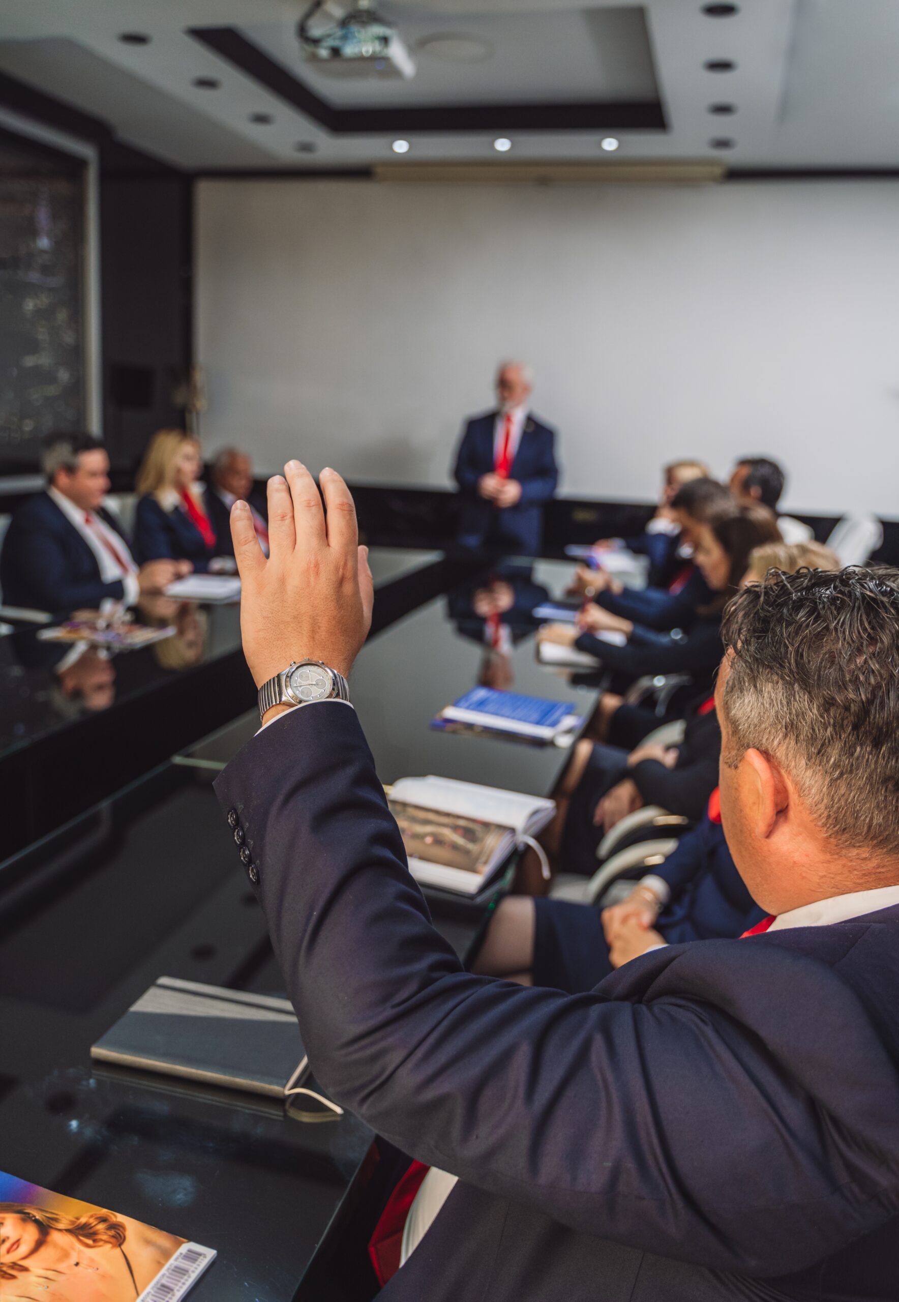 Senior,Businessman,Raising,Hand,To,Ask,Question,During,Meeting,At